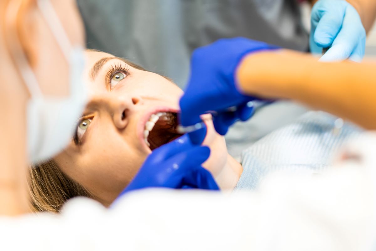 Oral surgery in Pickering - dentist performing a surgical tooth extraction under local anesthesia at Bayly Dental Clinic