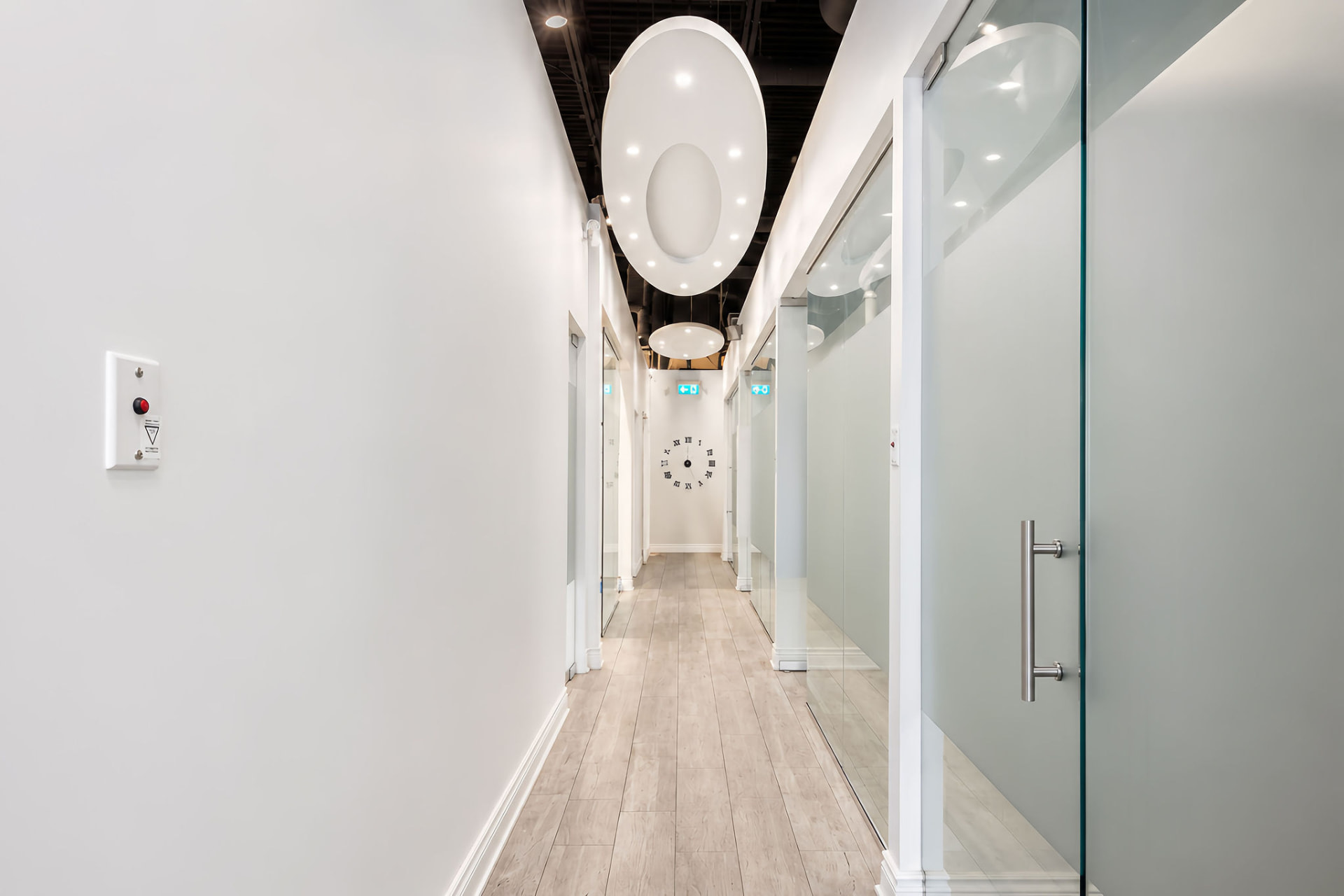 Bright hallway with glass operatory doors at Bayly Dental Clinic
