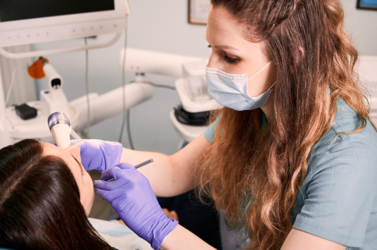 Dental hygienist performing teeth cleaning in Pickering using an ultrasonic scaler on a patient at Bayly Dental Clinic