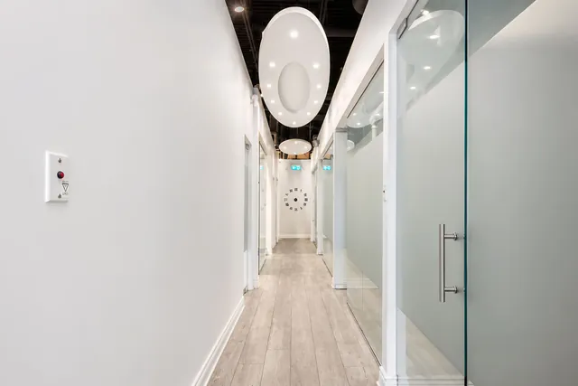 Bright hallway with glass operatory doors at Bayly Dental Clinic